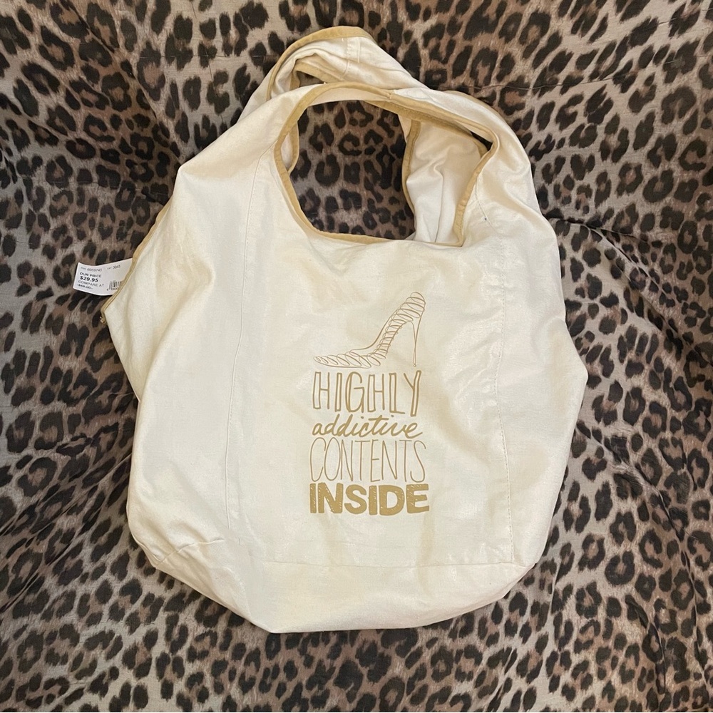 DSW white canvas tote with gold trim and graphics
